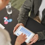 Pessoa se registra para votar usando um tablet em um posto eleitoral moderno.