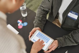 Pessoa se registra para votar usando um tablet em um posto eleitoral moderno.
