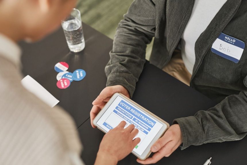 Pessoa se registra para votar usando um tablet em um posto eleitoral moderno.